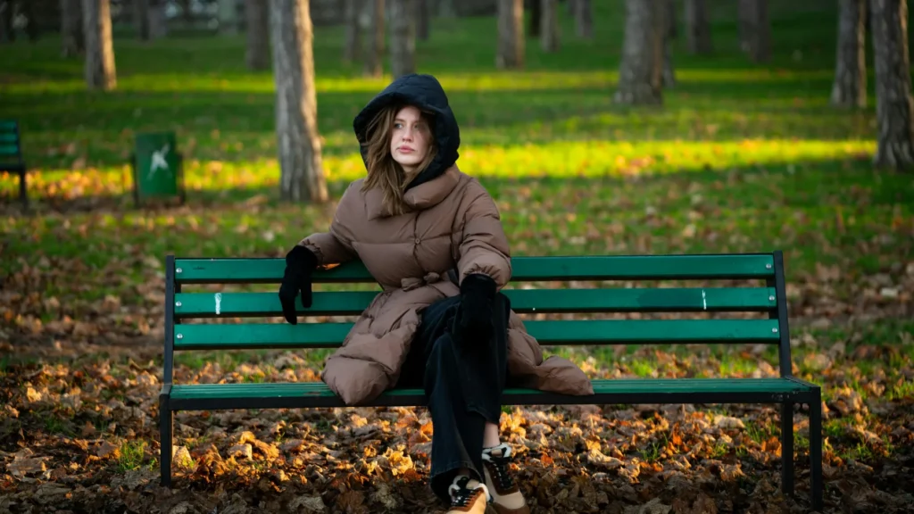 Femme assise seule sur un banc dans un parc arboré