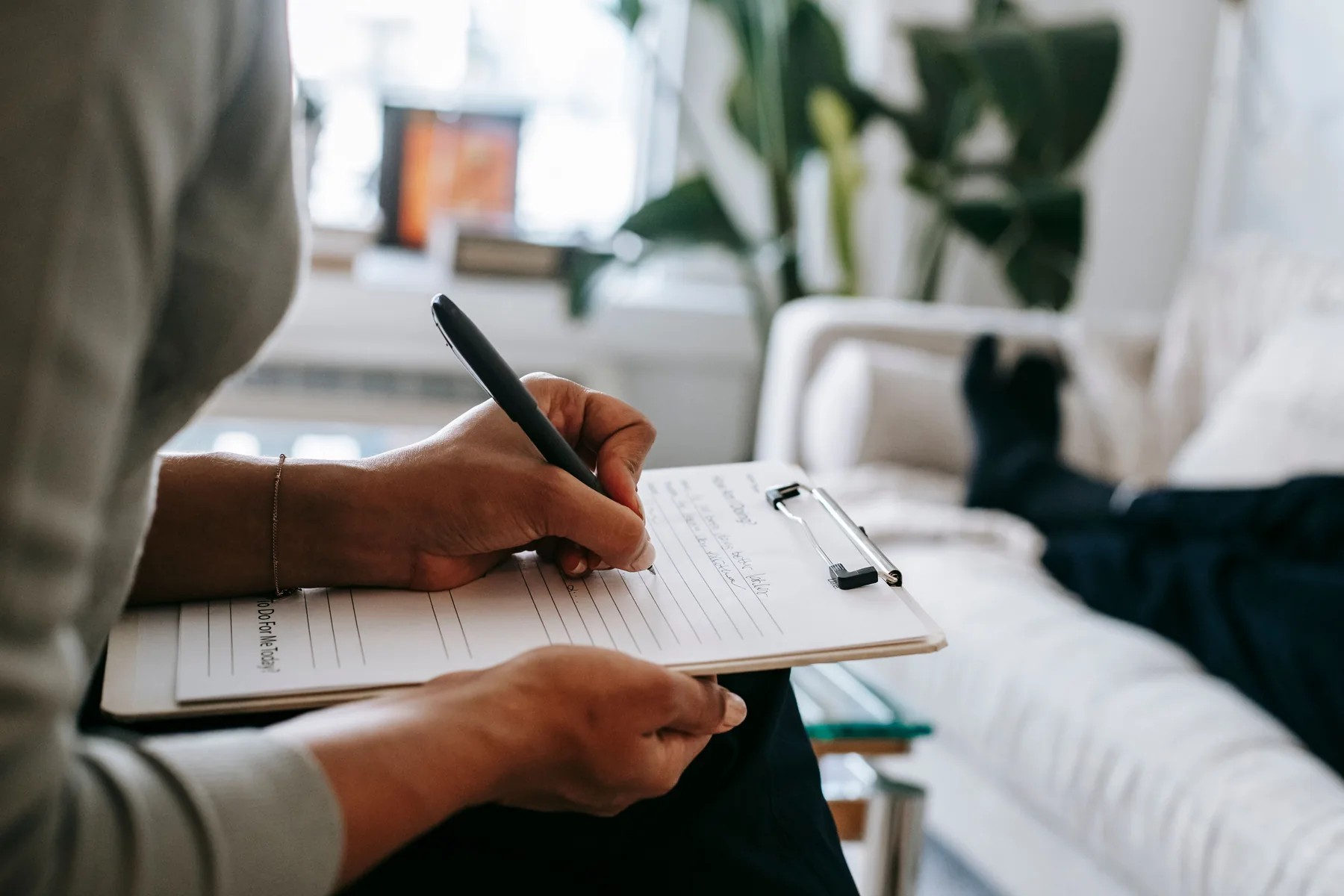 Thérapeute prenant des notes sur un formulaire pendant une séance